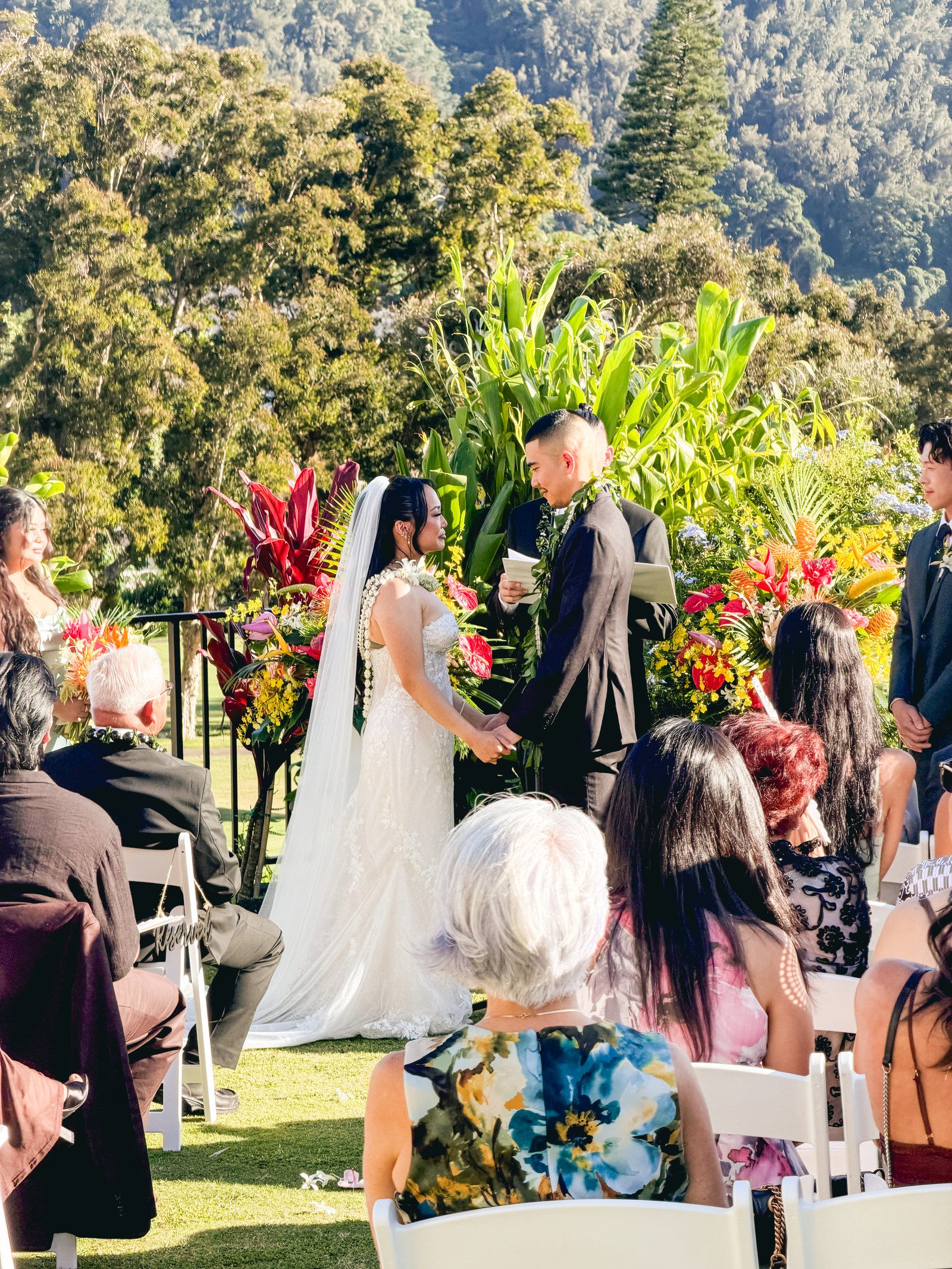 Josie and Scott holding hands during their outdoor wedding ceremony